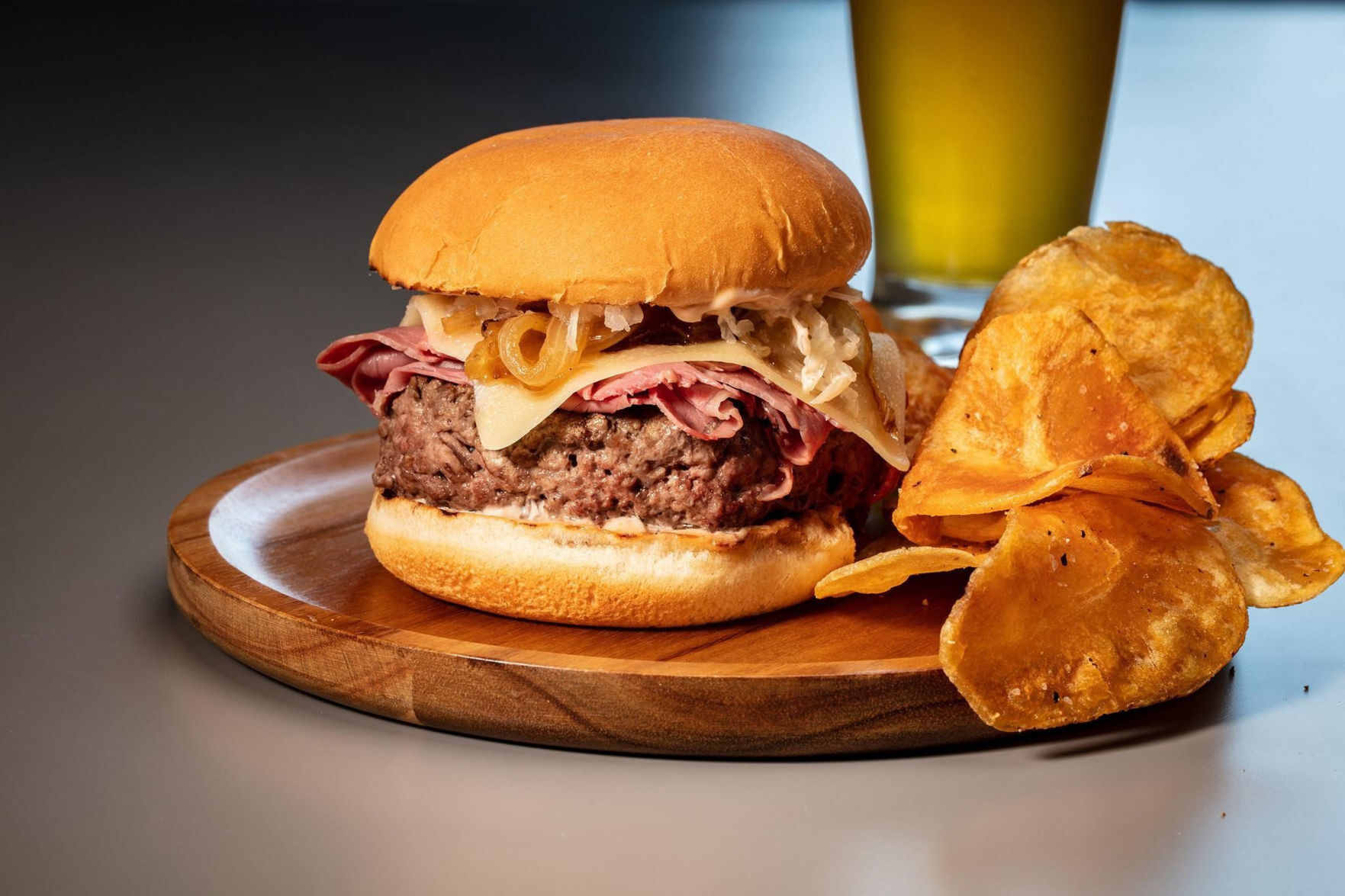 A cheeseburger-corned beef mashup is topped with onions, cheese, sauerkraut and a homemade dressing reminiscent of Thousand Island.